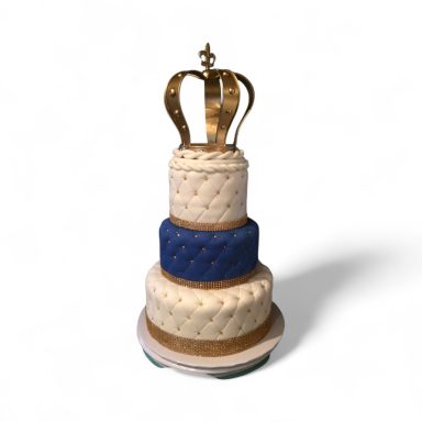 Three-tiered cake featuring a gold crown on top, with blue and cream decorations.