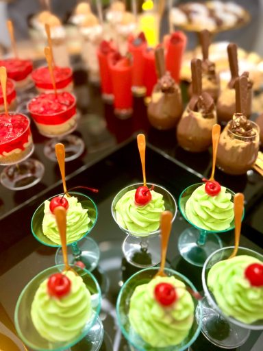 Colorful dessert assortment featuring green mousse, red jellies, and chocolate treats.