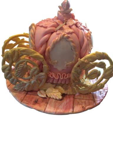 Decorative cake shaped like a pumpkin with ornate, golden accents and floral details.