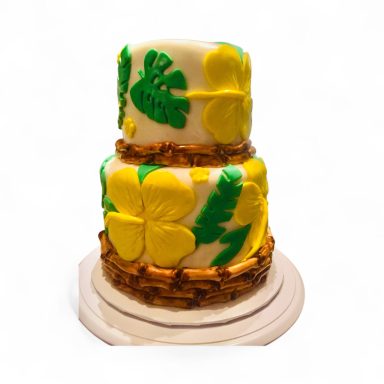 Two-tiered cake decorated with yellow flowers and green leaves.