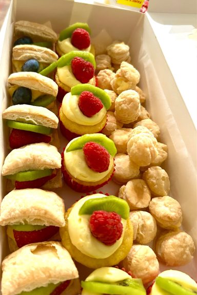 Assorted pastries including fruit-topped desserts and sweet dough balls.