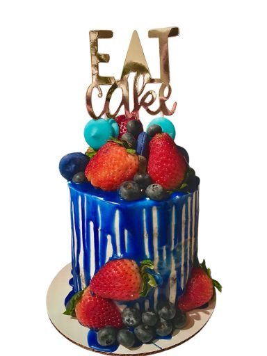 A blue drip cake topped with strawberries, blueberries, and an "EAT CAKE" sign.