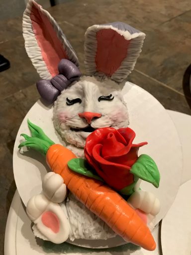 A cute bunny holding a carrot and a rose, decorated in pastel colors.