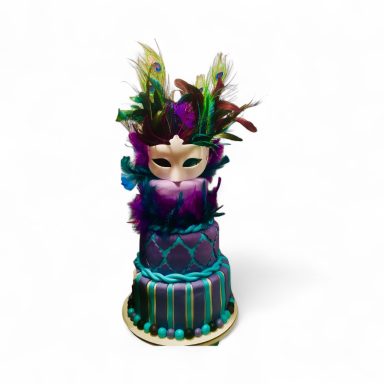 Colorful cake featuring a mask and feather decorations, designed for a festive occasion.